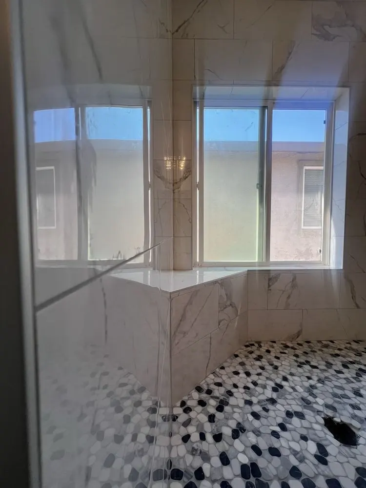 Bathroom with large marble-look windows and a mosaic shower floor