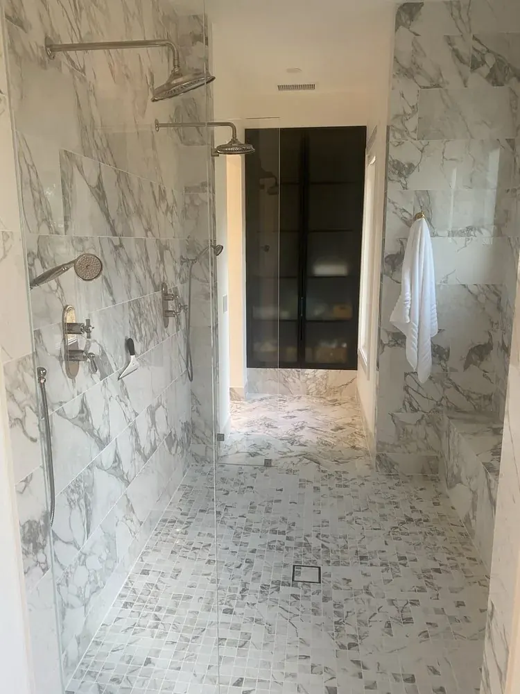 Primary bath with marble-look porcelain and a freestanding tub
