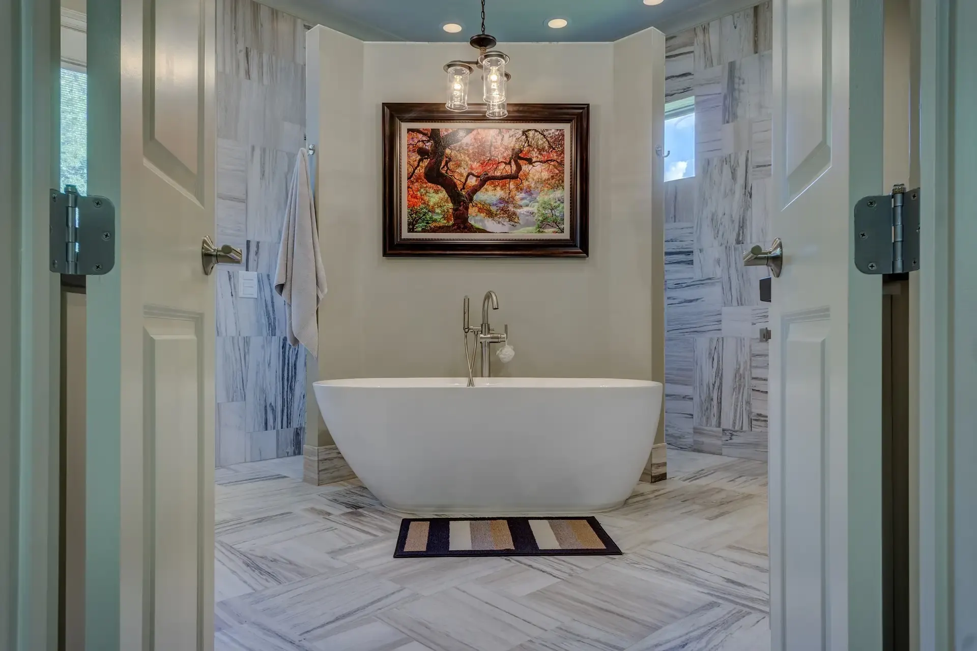 Bathroom with marble-look tile walls and a freestanding tub