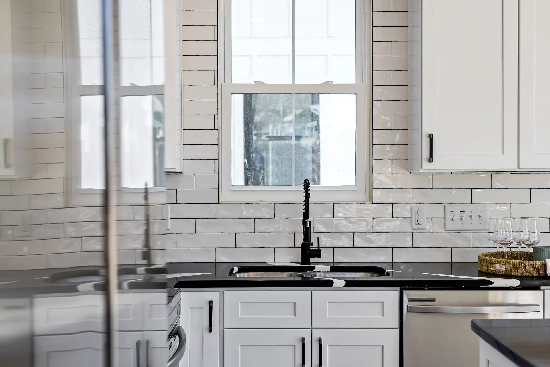 White subway tile kitchen backsplash with black countertops