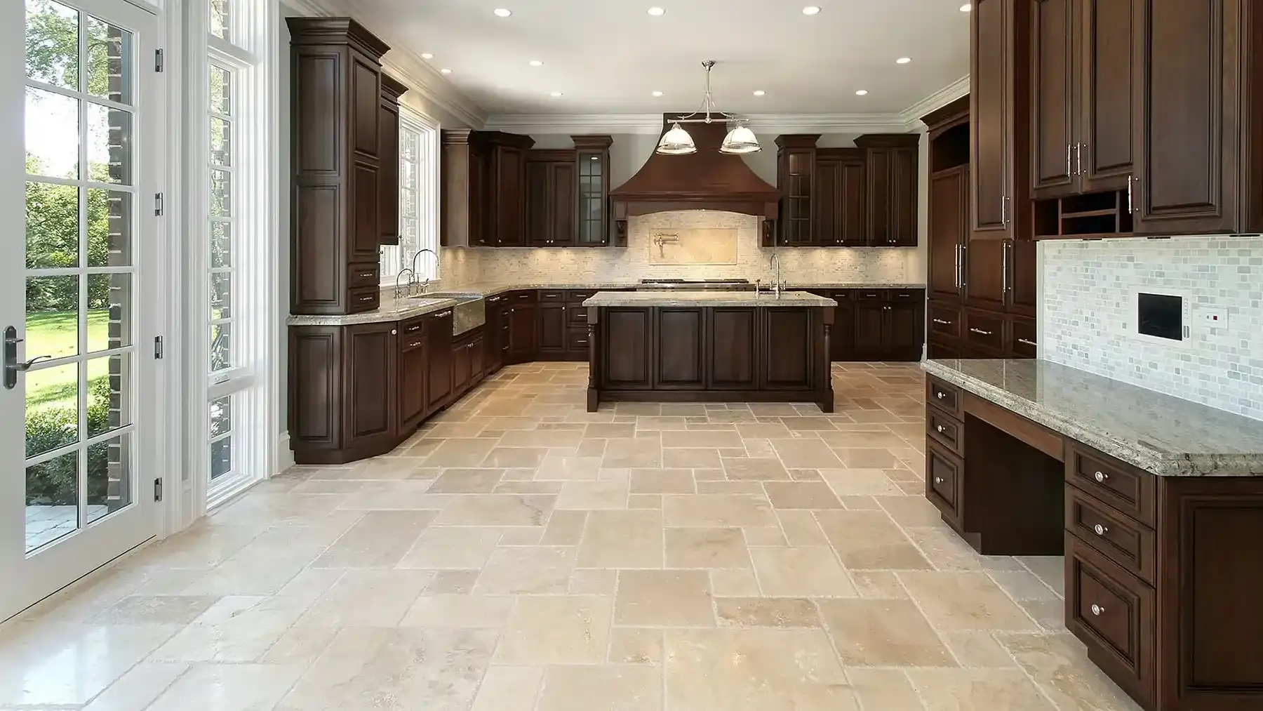 Large kitchen with travertine-look floor tile and dark wood cabinets