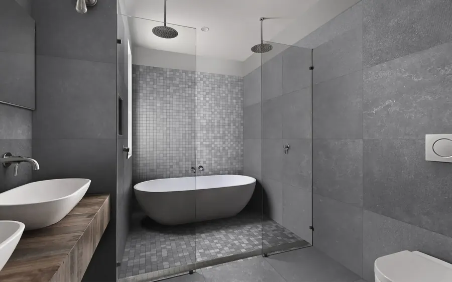 Gray stone tile bathroom with a freestanding tub and mosaic floor