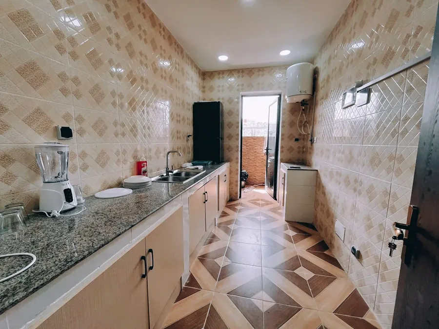 Kitchen with patterned terracotta and cream floor tile